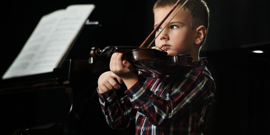 Niño tocando el violín para hacer música